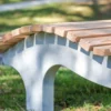 Wellenliege aus Beton und Lärchenholz steht in einem begrünten Außenbereich
