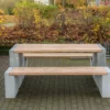 Massiver Tisch aus Sichtbeton und Lärchenholz steht auf öffentlichem Platz