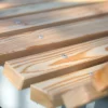 Wellenliege aus Beton und Lärchenholz steht in einem begrünten Außenbereich