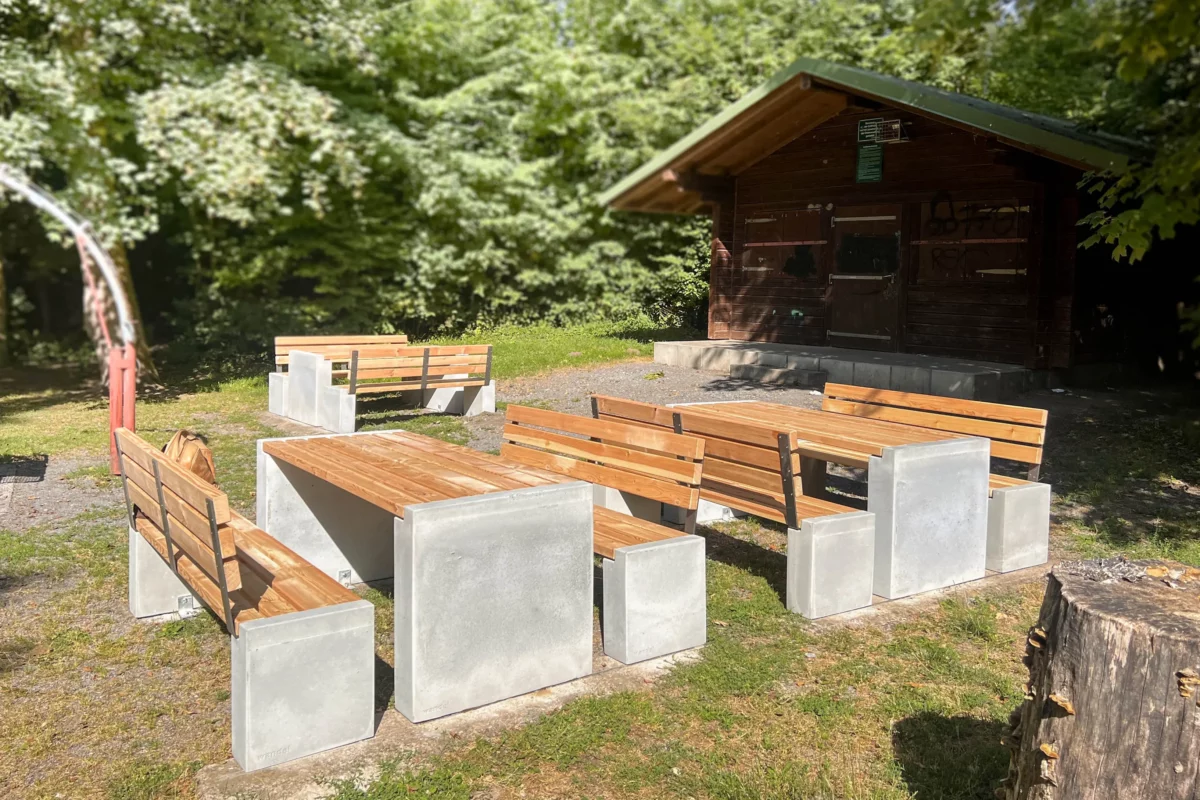 Massiver Tisch aus Sichtbeton und Lärchenholz steht auf öffentlichem Platz