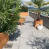 Verschieden große Pflanzkästen aus Holz stehen bepflanzt auf einer privaten Terrasse