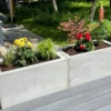 Bunt bepflanzter Trog aus Beton steht in öffentlichem Bereich