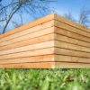 Hochbeet aus Lärchenholz steht in einem begrünten Garten