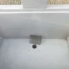 Zapfbrunnen aus Sichtbeton steht auf einem öffentlichen Gelände