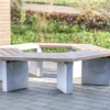 Rundbank mit Lärchenholzlatten, Rückenlehne und Betonfüßen steht auf einem öffentlichen Platz.