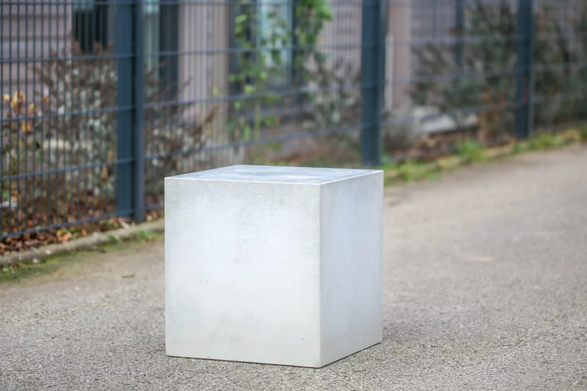 Massiver Poller aus Sichtbeton steht auf öffentlichem Weg zur Durchfahrtsbeschränkung