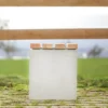 Hocker aus Beton mit Sitzauflage aus Lärchenholz steht auf öffentlicher Grünanlage
