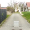 Massiver Poller aus Sichtbeton steht auf öffentlichem Weg zur Durchfahrtsbeschränkung