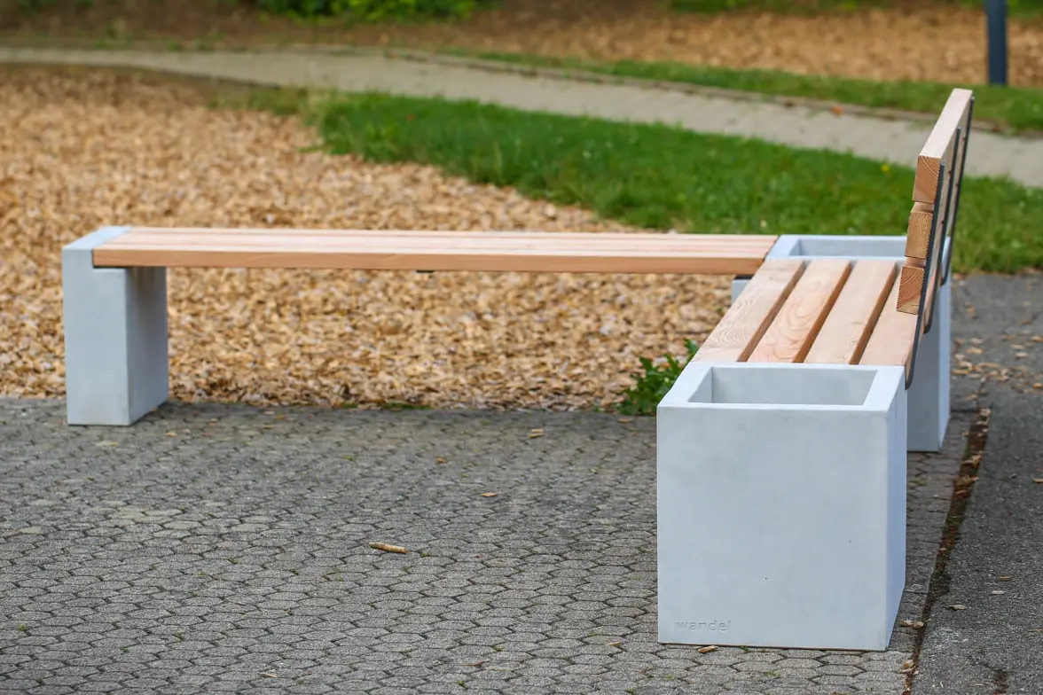 Eckbank aus Beton und Lärchenholz steht auf öffentlichem Platz
