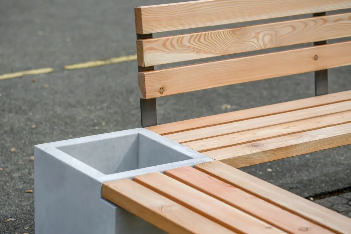 Eckbank aus Beton und Lärchenholz steht auf öffentlichem Platz