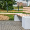Eckbank aus Beton und Lärchenholz steht auf öffentlichem Platz