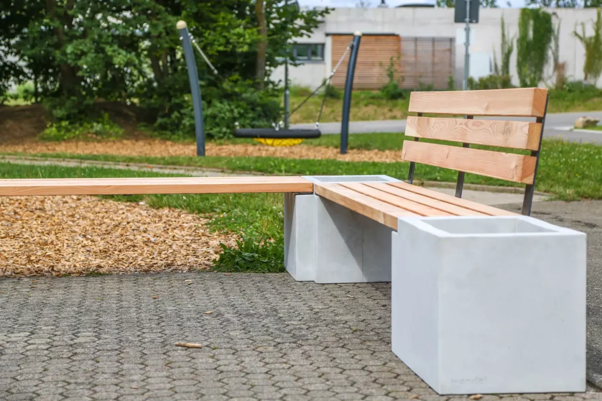 Eckbank aus Beton und Lärchenholz steht auf öffentlichem Platz