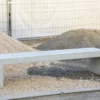 Massive Sitzbank aus Sichtbeton, optional mit Sitzauflage aus Holzdielen, steht in öffentlichem Bereich