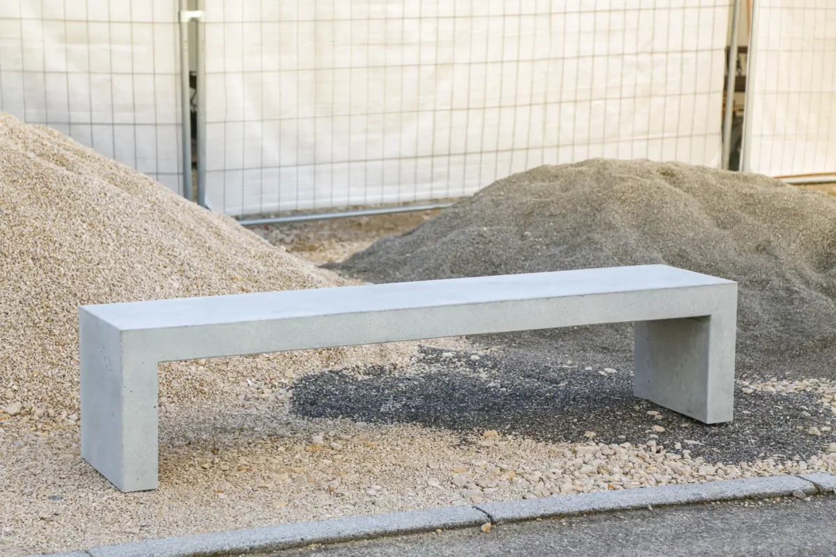 Massive Sitzbank aus Sichtbeton, optional mit Sitzauflage aus Holzdielen, steht in öffentlichem Bereich