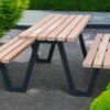 Moderne Sitzgruppe aus schwarzem Gestell und Holzauflagen steht auf öffentlichem Grund