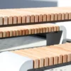 Tisch für Außenbereich mit abgerundeten Standfüßen aus Beton und längs verlaufenden Holzdielen steht auf öffentlichem Grund