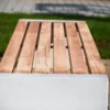 Sitzbank in Überbreite aus Beton und Lärchenholz steht auf einer öffentlichen Fläche