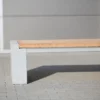 Sitzbank in Überbreite aus Beton und Lärchenholz steht auf einer öffentlichen Fläche