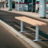 Sitzbank aus Stahl und Lärchenholz steht an einer viel befahrenen Straße