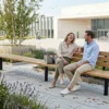 Modulare Reihenbank Tibia mit Holzauflagen auf einem modernen Stadtplatz