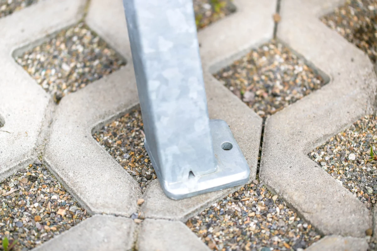 Liegebank aus Metall und Holz steht im Außenbereich vor einer grünen Wiese