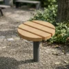 Moderner Hocker Tibia aus Holz und Stahl als Stadtmöbel im Park